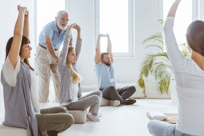 adults stretching in bright studio